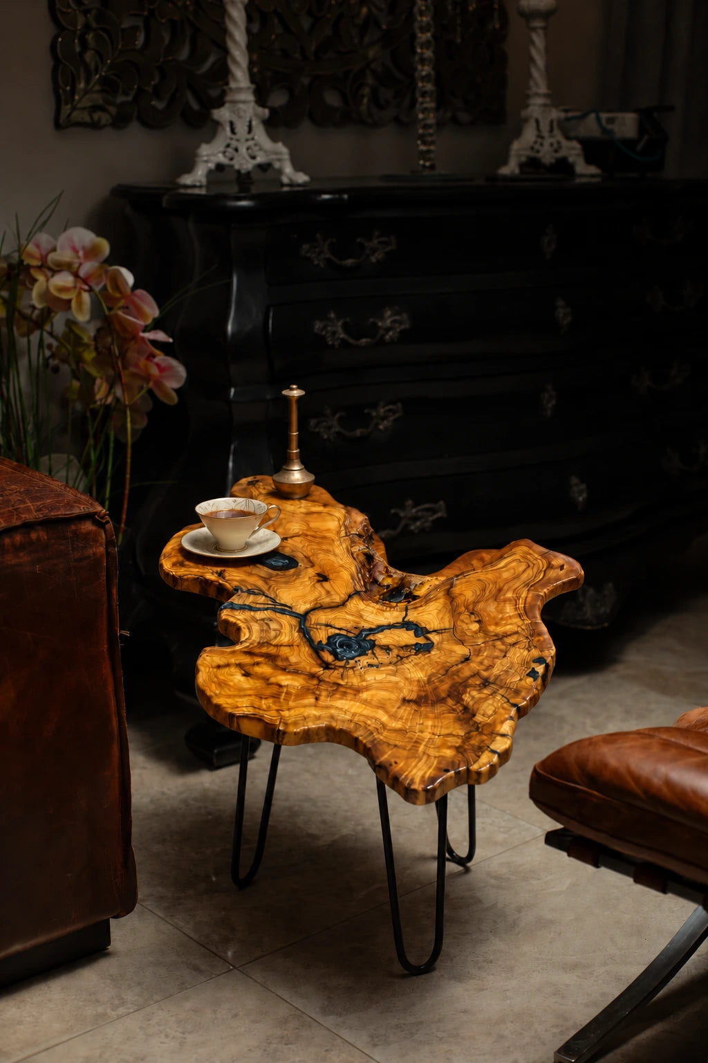 AI-styled view of Zitun Atelier table 078, an olive wood resin small coffee table with black resin veins, in a dark interior beside leather seating.
