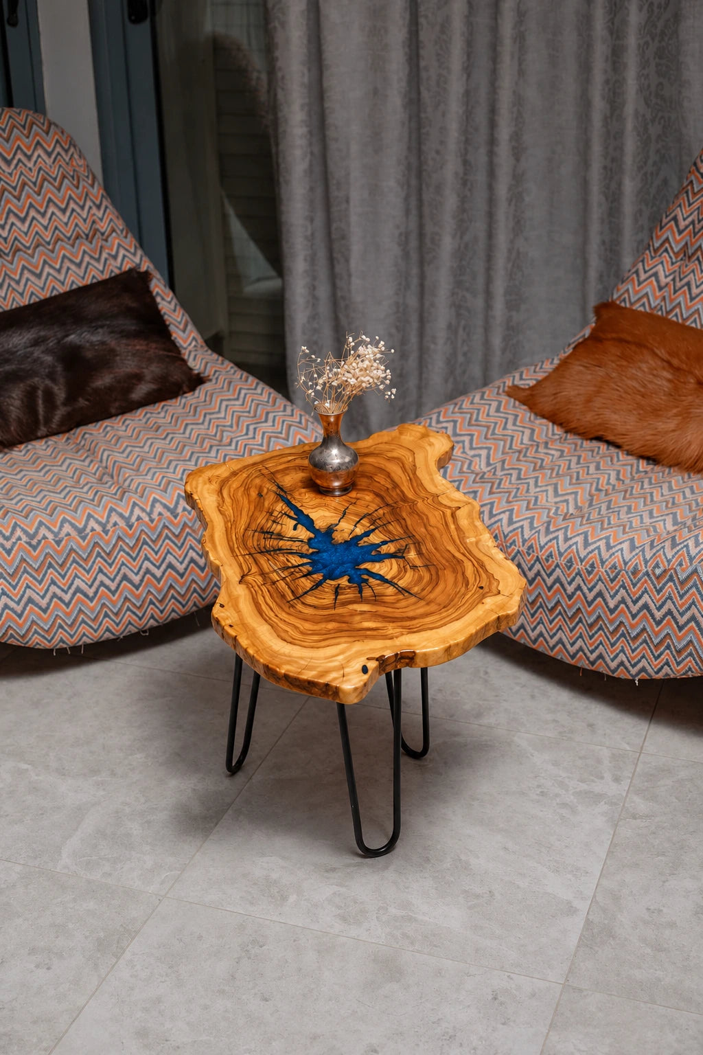 AI-styled view of Zitun Atelier table 079, an olive wood resin side table with blue starburst resin, viewed from above between two upholstered armchairs.
