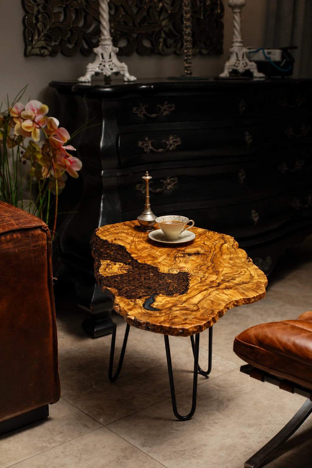 AI-styled view of Zitun Atelier table 081, an olive wood resin side table with coffee bean resin, in a dark interior beside leather seating.