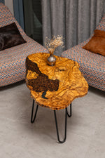 AI-styled view of Zitun Atelier table 081, an olive wood resin side table with coffee bean resin, viewed from above between two upholstered armchairs.