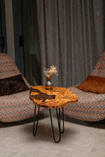 AI-styled view of Zitun Atelier table 081, an olive wood resin side table with coffee bean resin, in a lounge setting with a vase on the tabletop.