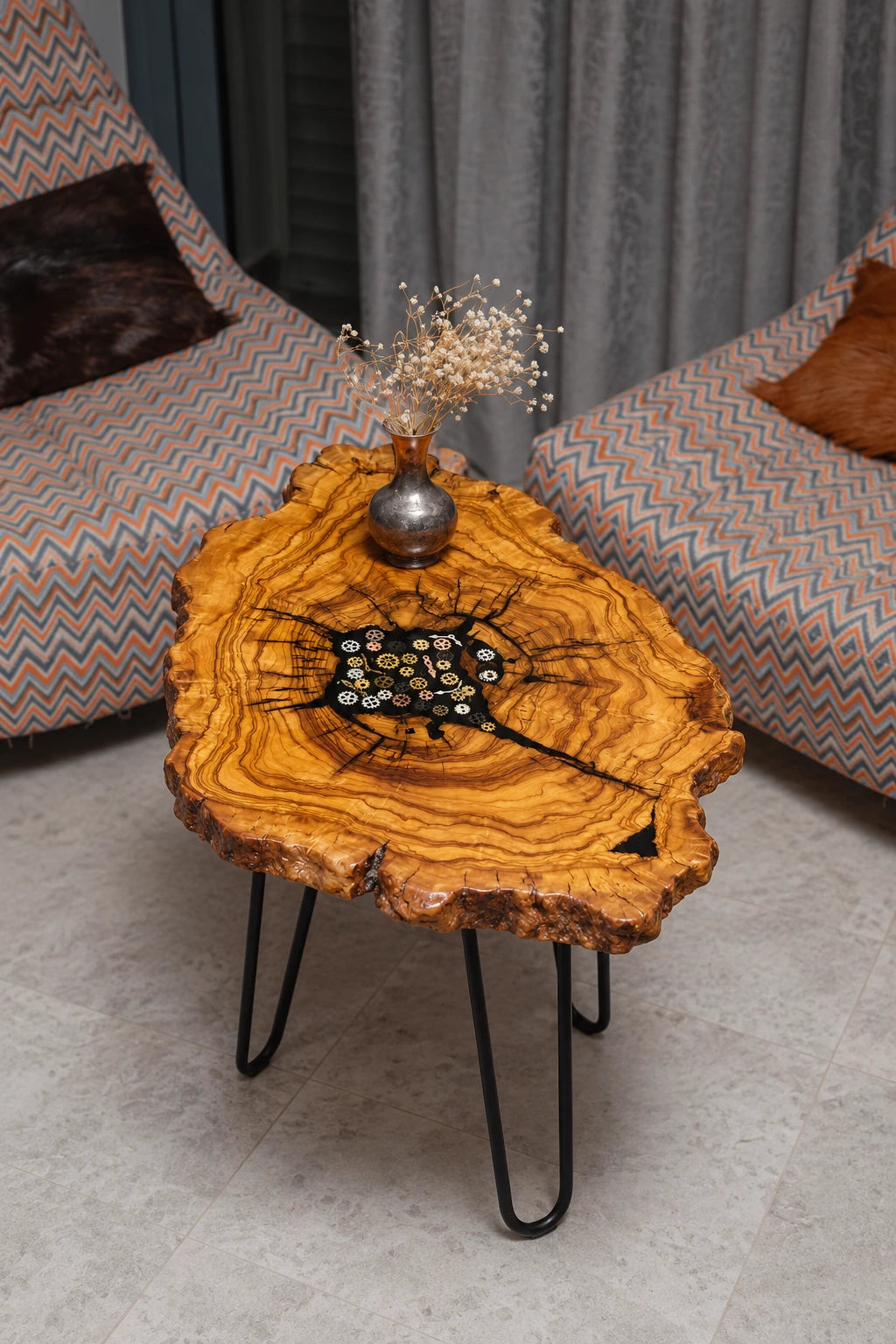 AI-styled view of Zitun Atelier table 083, an olive wood resin side table with black resin steampunk gears, viewed from above between two upholstered armchairs.