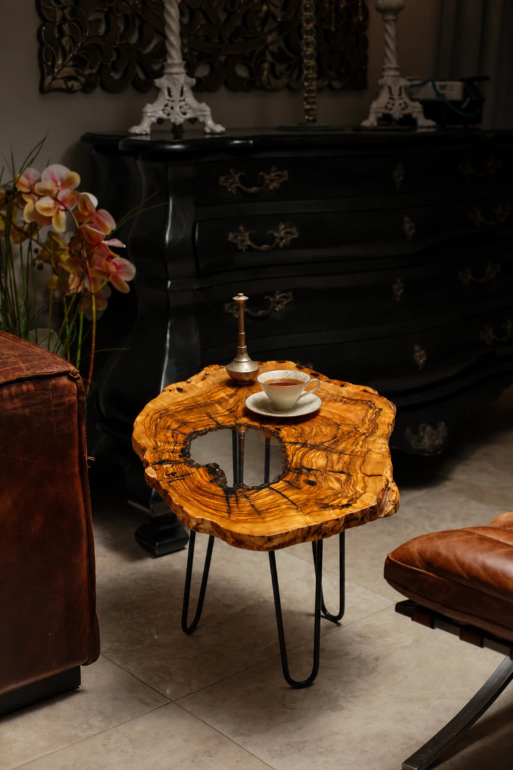 AI-styled view of Zitun Atelier table 084, an olive wood resin side table with white resin center, in a dark interior beside leather seating.