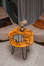 AI-styled view of Zitun Atelier table 084, an olive wood resin side table with white resin center, viewed from above between two upholstered armchairs.