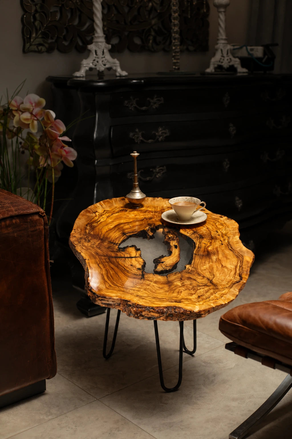 AI-styled view of Zitun Atelier table 089, an olive wood resin side table with white resin center, in a dark interior beside leather seating.