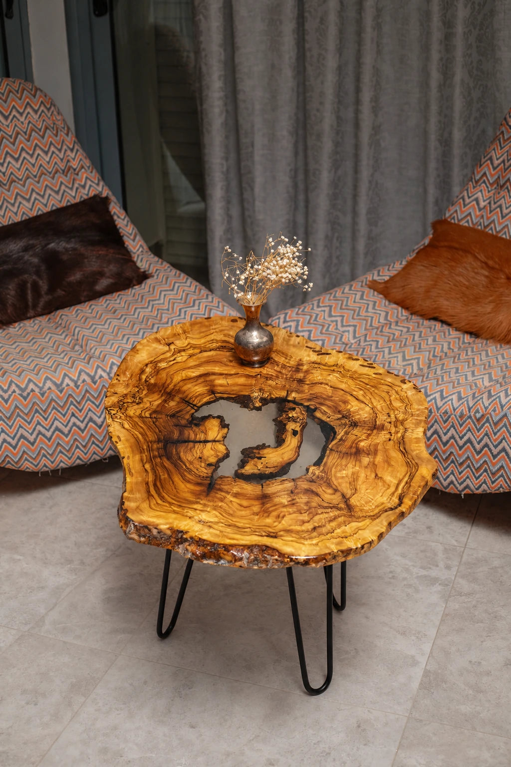 AI-styled view of Zitun Atelier table 089, an olive wood resin side table with white resin center, viewed from above between two upholstered armchairs.