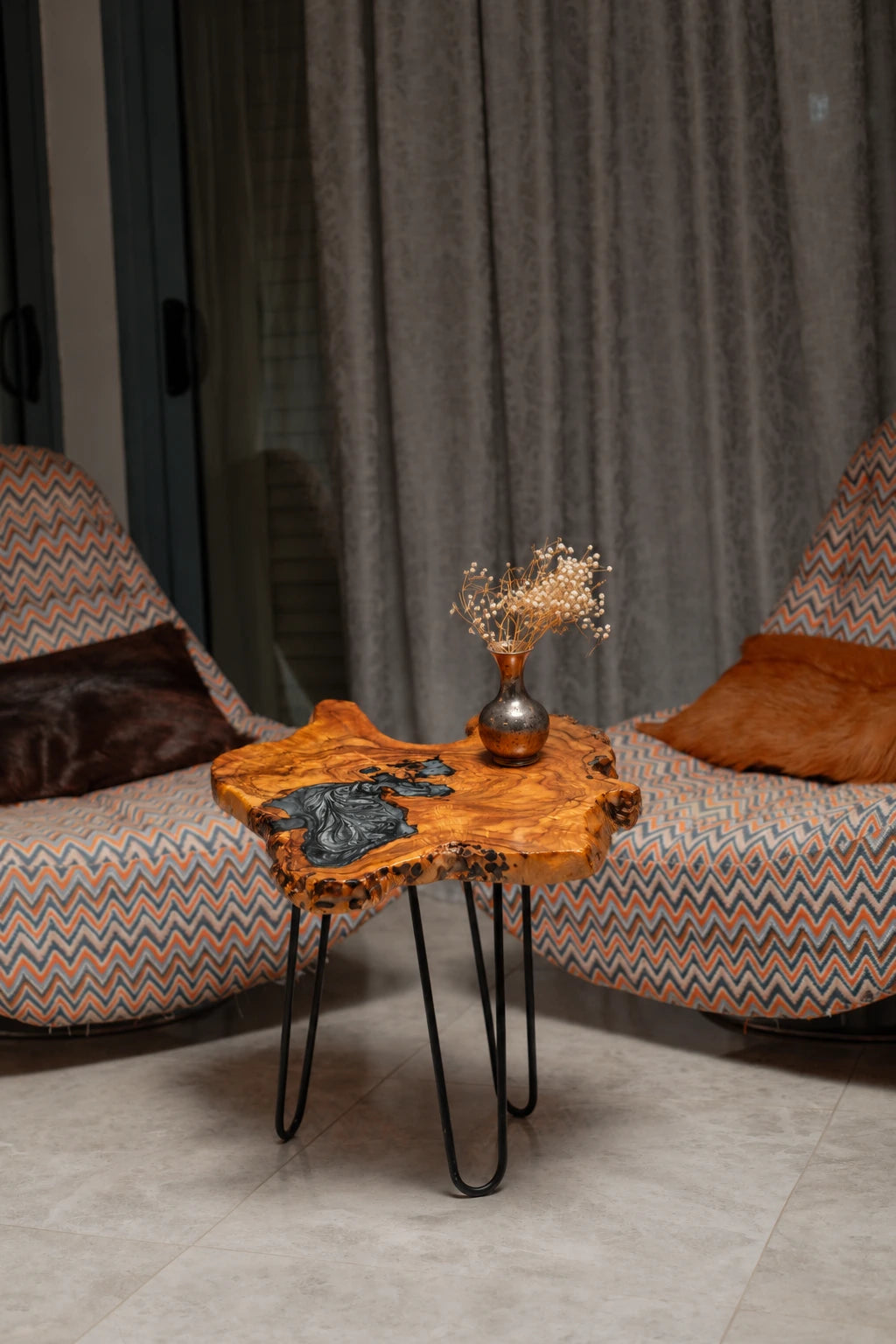 AI-styled view of Zitun Atelier table 091, an olive wood resin side table with black marble resin, in a lounge setting with a vase on the tabletop.