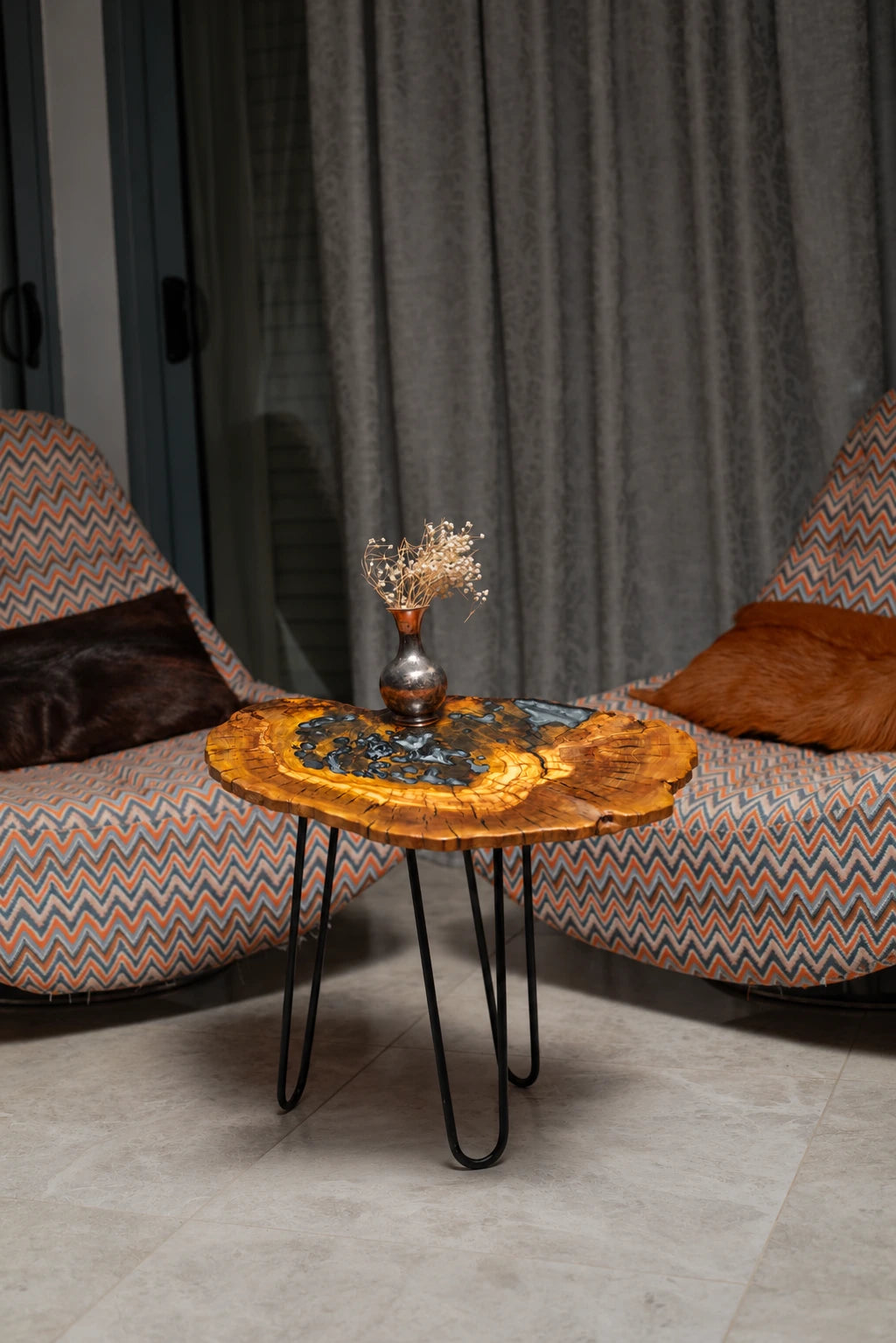 AI-styled view of Zitun Atelier table 092, an olive wood resin side table with black pebble resin, in a lounge setting with a vase on the tabletop.