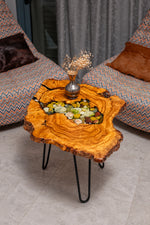 AI-styled view of Zitun Atelier table 093, an olive wood resin side table with sea shell pebble resin, viewed from above between two upholstered armchairs.