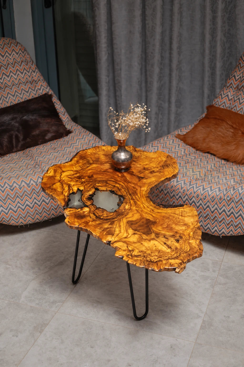 AI-styled view of Zitun Atelier table 095, an olive wood resin side table with white resin inlay, viewed from above between two upholstered armchairs.