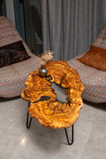 AI-styled view of Zitun Atelier table 096, an olive wood resin small coffee table with white resin river, viewed from above between two upholstered armchairs.