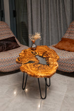 AI-styled view of Zitun Atelier table 096, an olive wood resin small coffee table with white resin river, in a lounge setting with a vase on the tabletop.